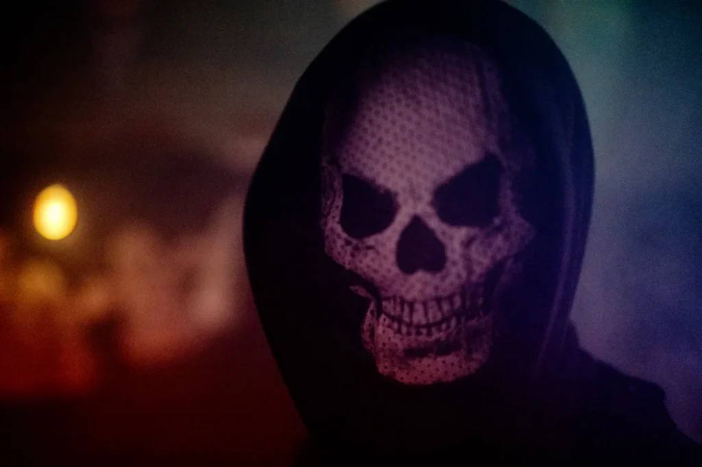 Figuur met een doodshoofdmasker onder een zwarte capuchon in de mist β Haunted House van Halloween HDL in Loosbroek